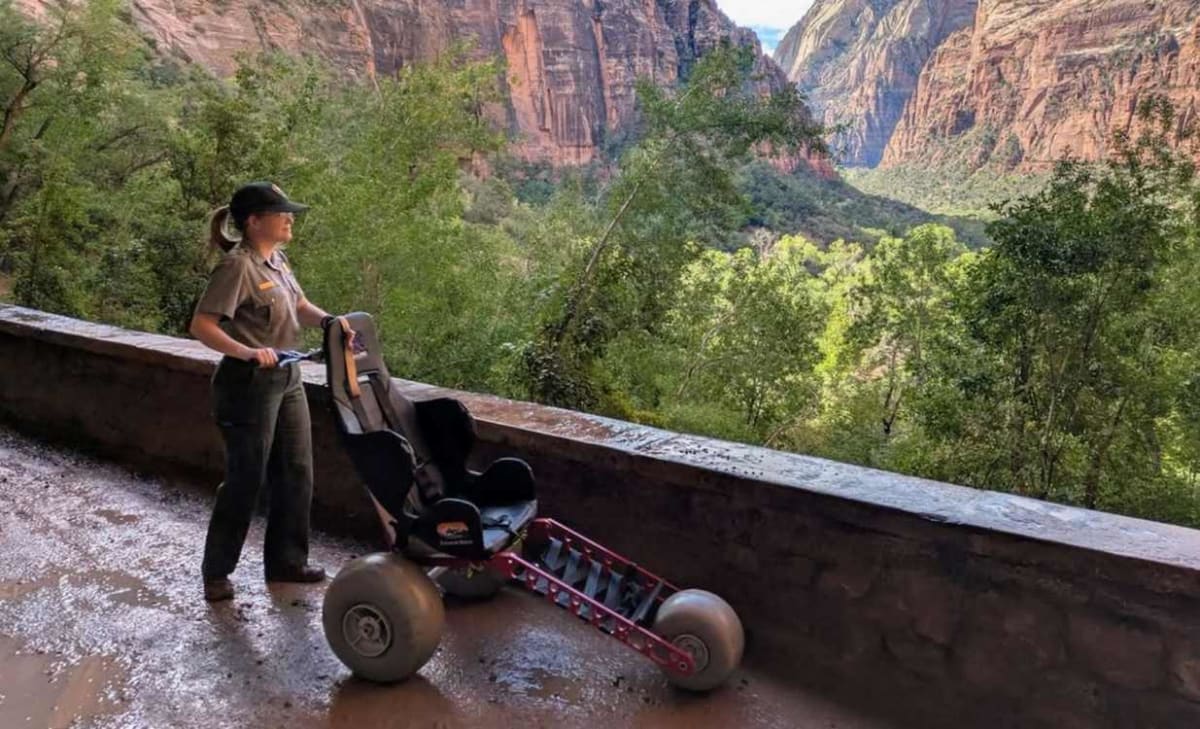 All-terrain wheelchair on Zion National Park trail with red canyon walls background
