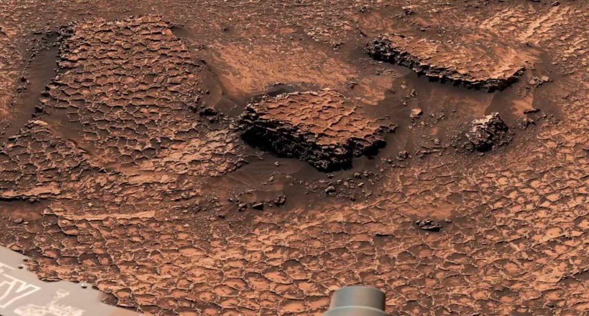 Honeycomb geometric patterns spread across red Martian landscape captured by Curiosity rover