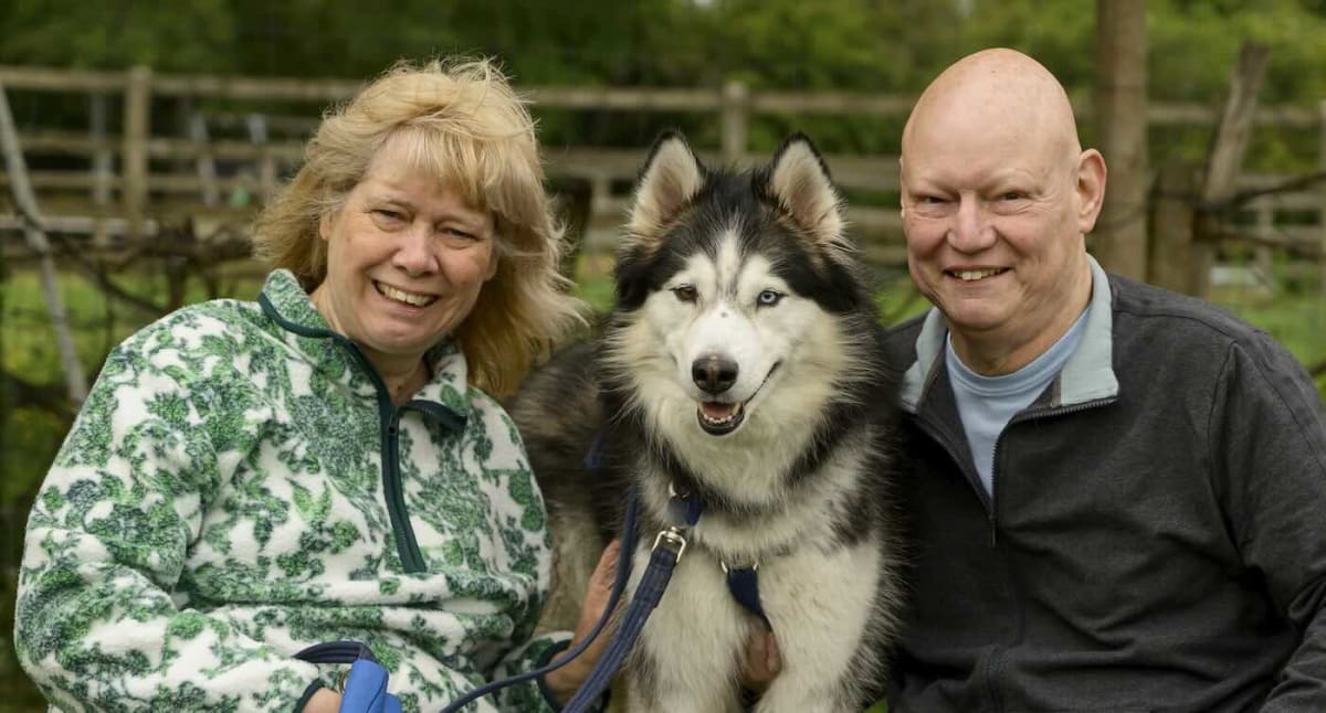 Nicole and Gary Wordsworth smiling with a foster dog at their home in Buckinghamshire
