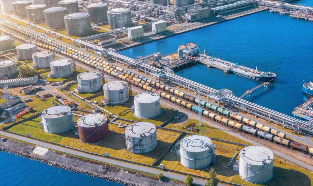 Modern oil refinery with industrial towers and pipes against blue sky