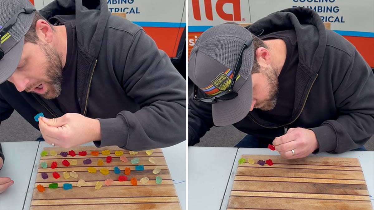 Man eating colorful gummy bears with cocktail stick while attempting world record