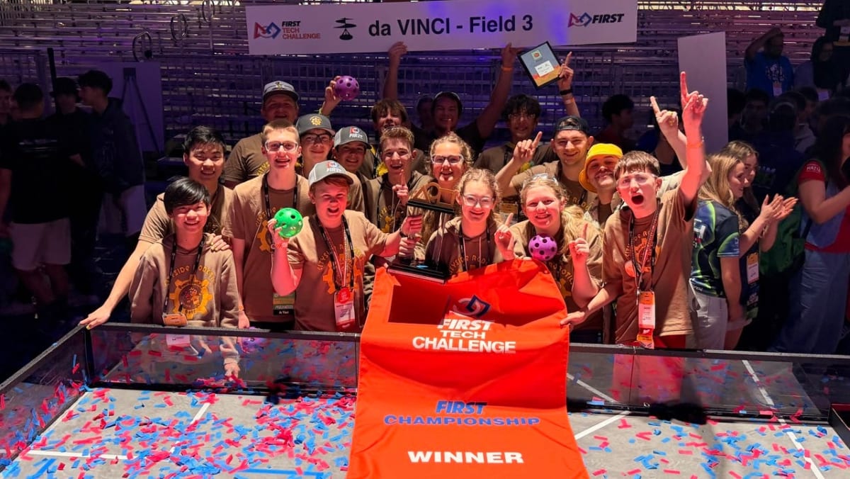 Middle school students celebrating with their championship-winning robot at FIRST Tech Challenge World Championships