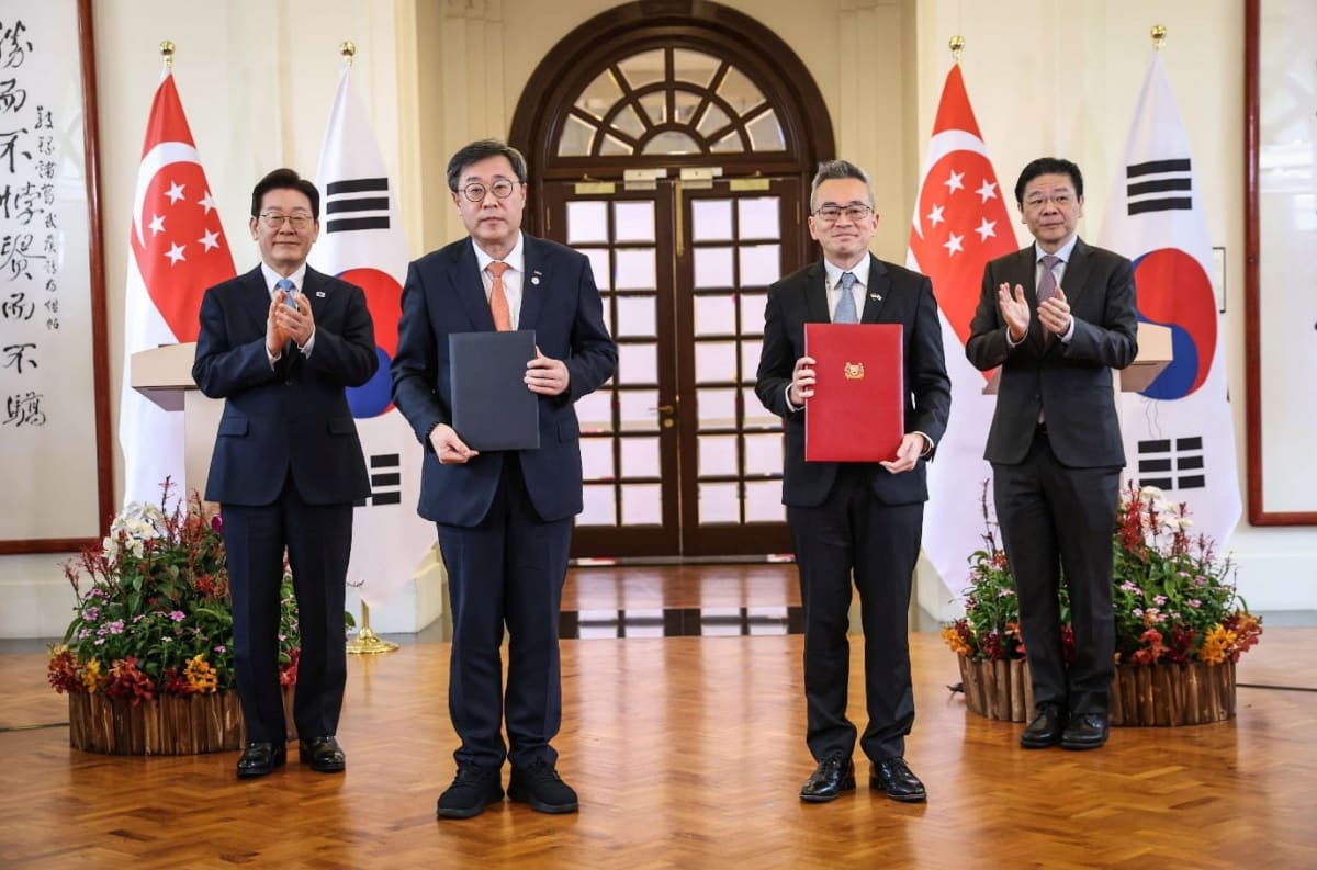 Singapore and South Korean officials shake hands at formal MOU signing ceremony