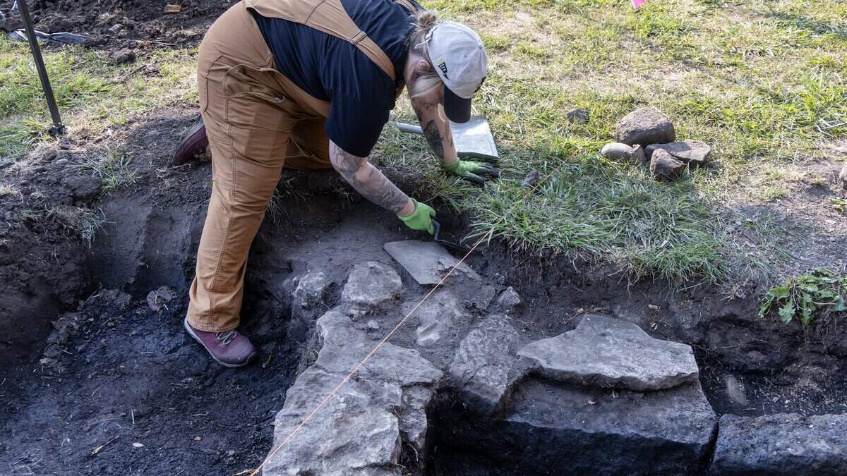 University of Idaho archaeology students carefully excavating soil at historic farmstead near Boise