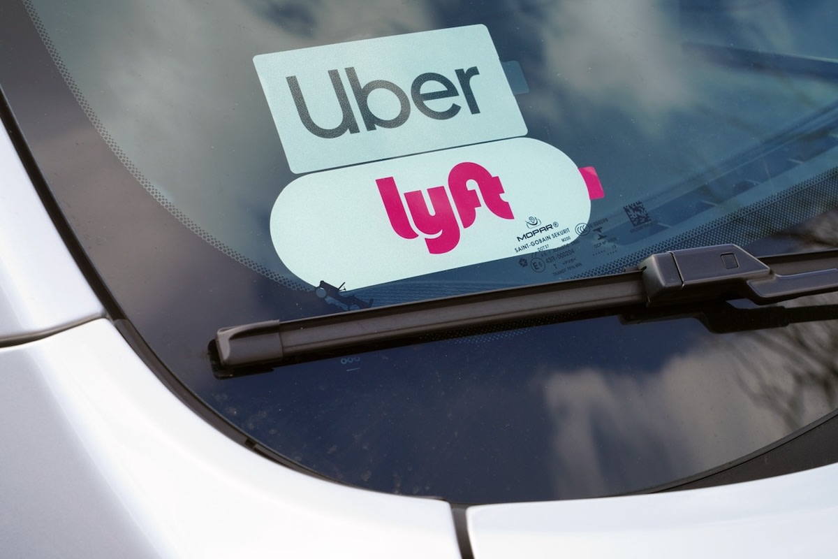 Electric vehicle charging at station with rideshare decal on windshield in California