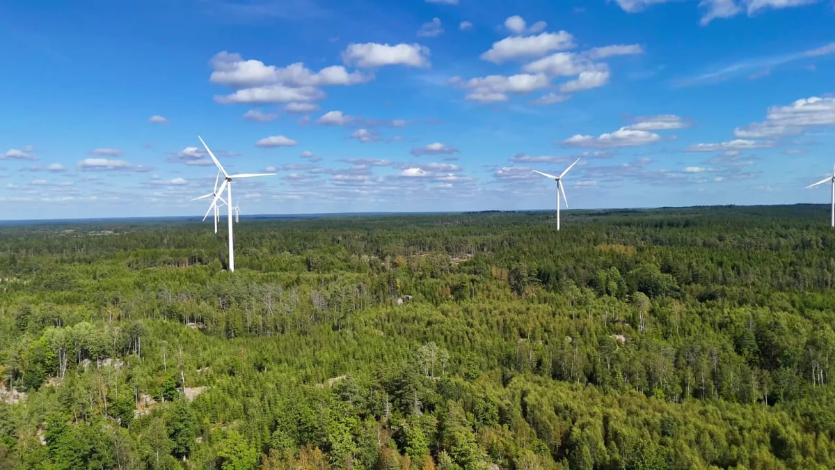 ** Modern industrial port facility with renewable energy infrastructure against Swedish coastal landscape