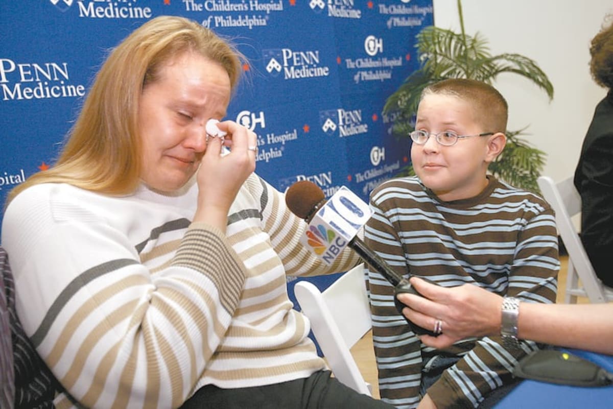 ** Mother Nancy Haas wiping tears while discussing her son Corey's restored vision after gene therapy treatment