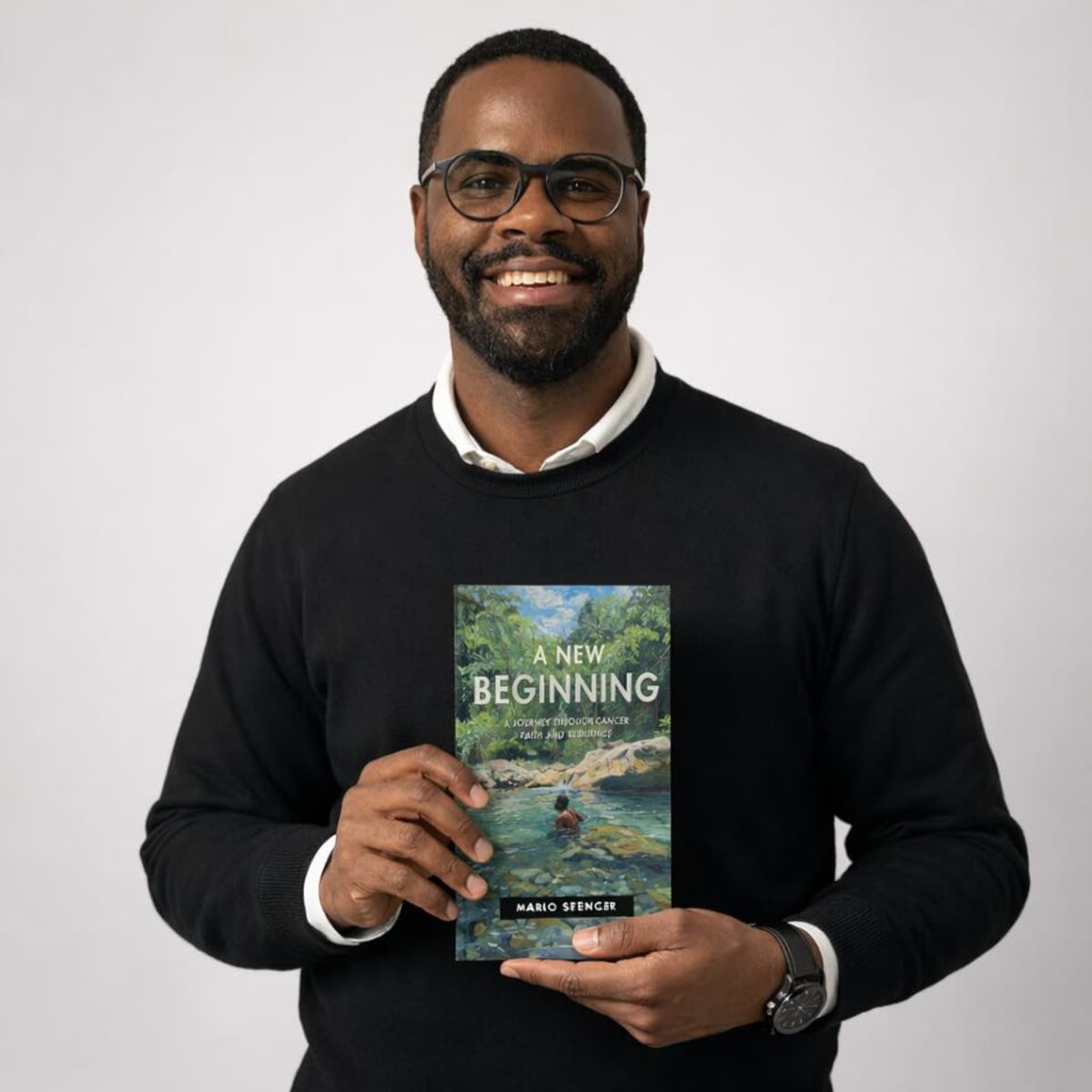 ** Mario Spencer holding his memoir "A New Beginning" about surviving teenage cancer through faith