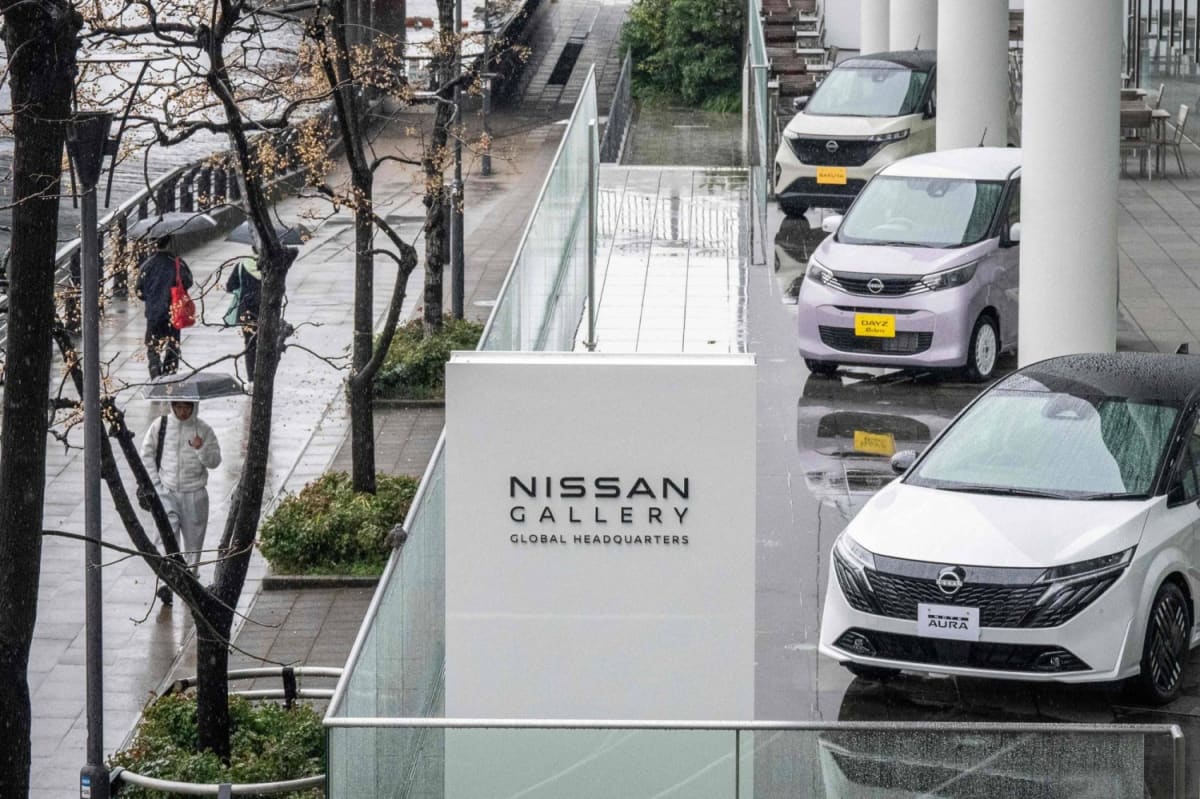 Nissan automotive factory workers collaborating on production line in Japan manufacturing facility