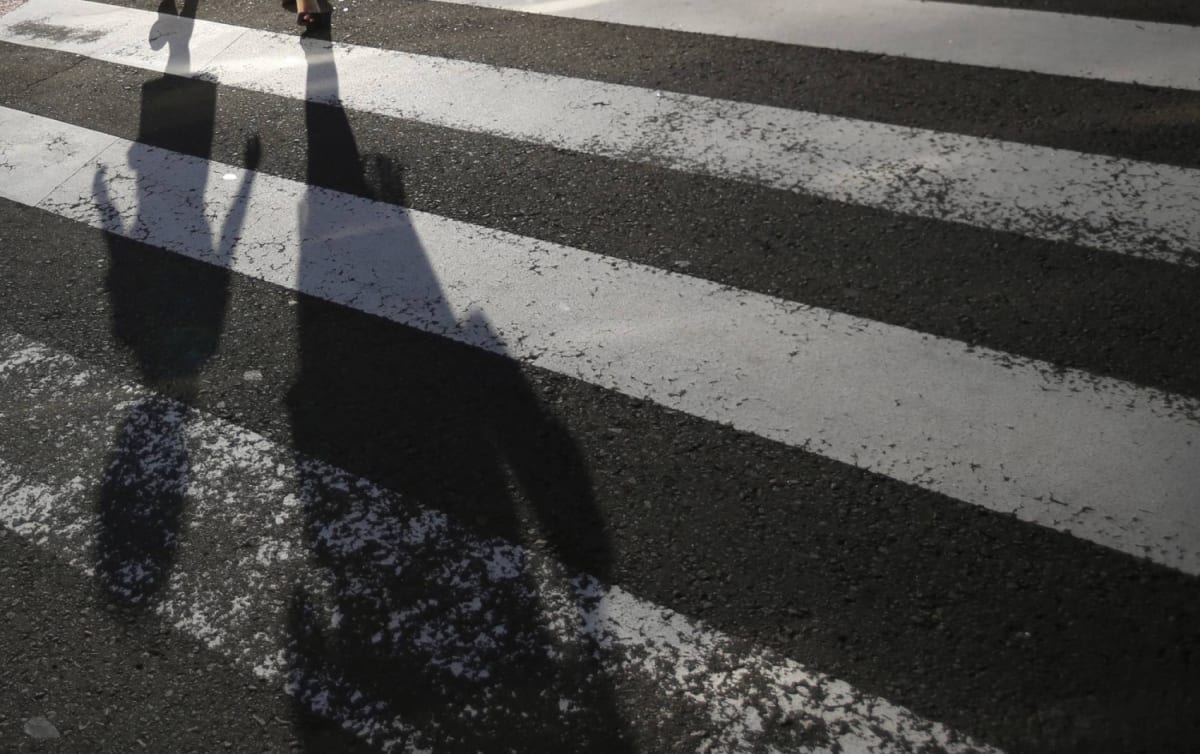 Japanese parent holding child's hand while walking together, representing single parent families supported by new policy