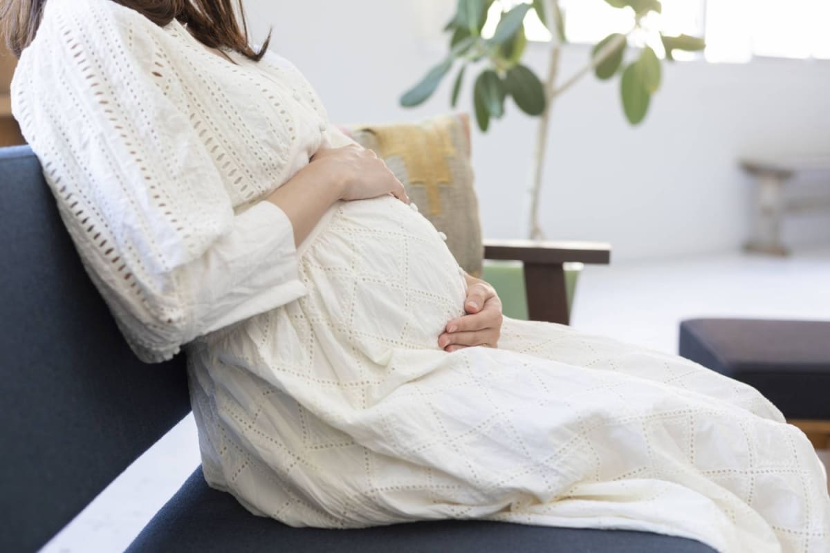 Pregnant woman smiling during prenatal checkup with healthcare provider in modern medical office