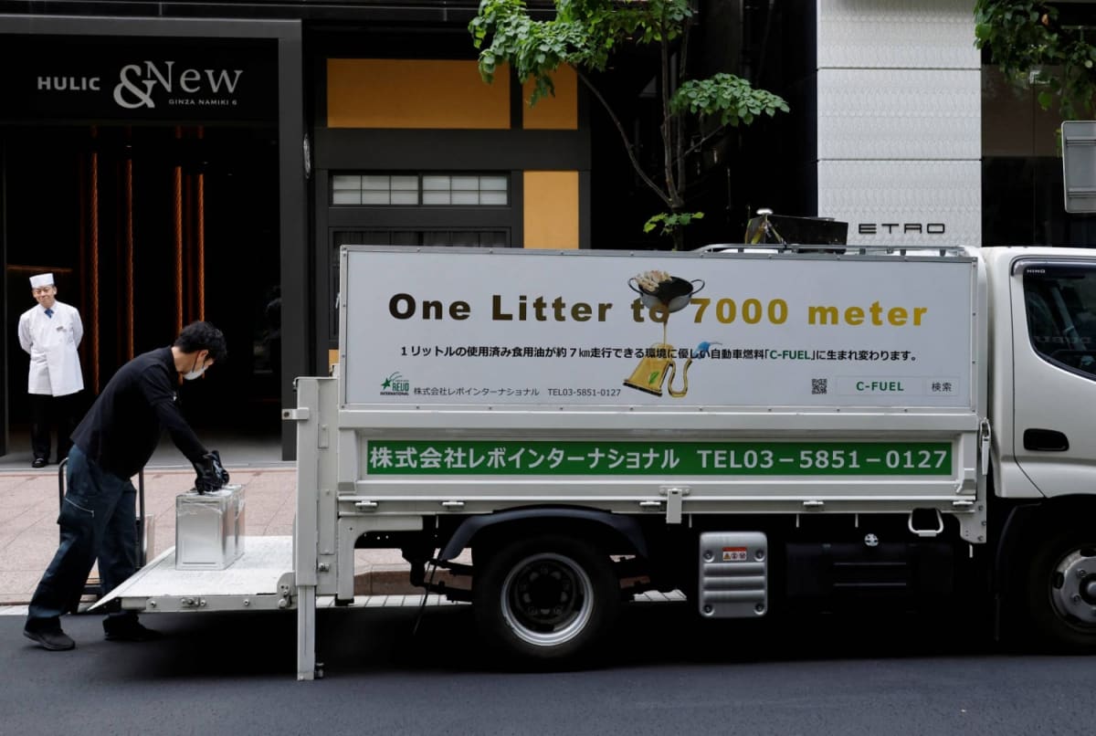 Japanese woman pouring used cooking oil into plastic bottle for sustainable aviation fuel recycling program