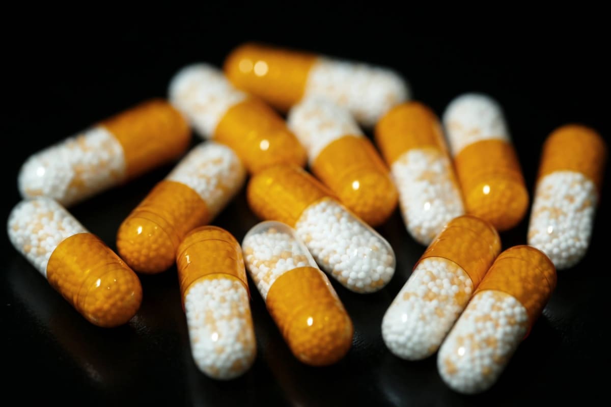 Japanese patient receiving prescription medication from pharmacist at modern healthcare facility