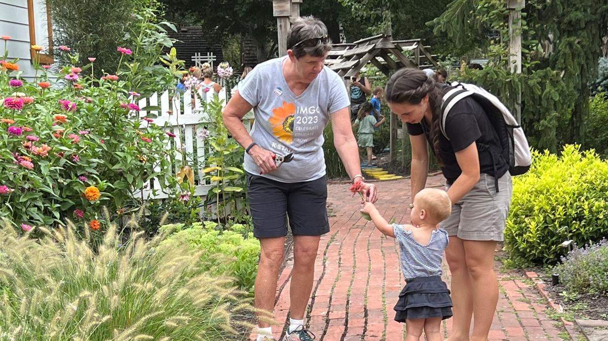 Master Gardener volunteers working together in a lush demonstration garden with flowering plants