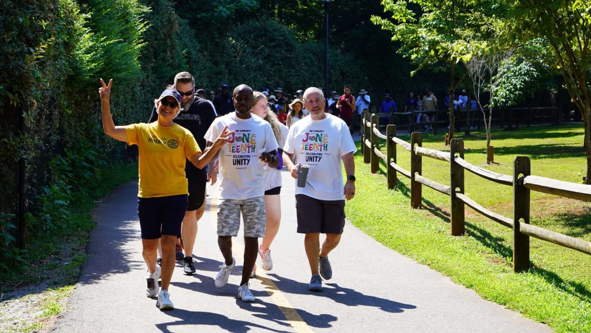 Families and police officers celebrating together at outdoor community event with bouncy houses