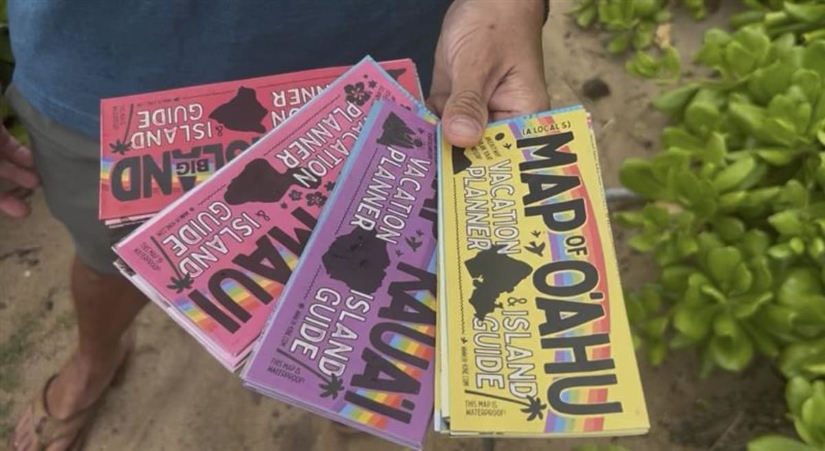 ** Upcycled surfboard mounted as beach cleanup station with collection nets and buckets at Hawaiian beach