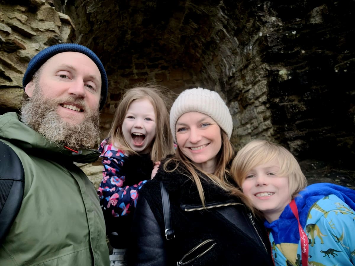 ** Young girl Chacha Robson holding medal while sitting in hospital bed, smiling at camera