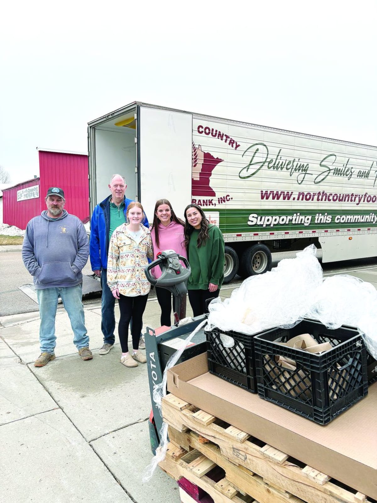 Volunteers including high school students and truck driver unloading food donations at Minnesota pantry