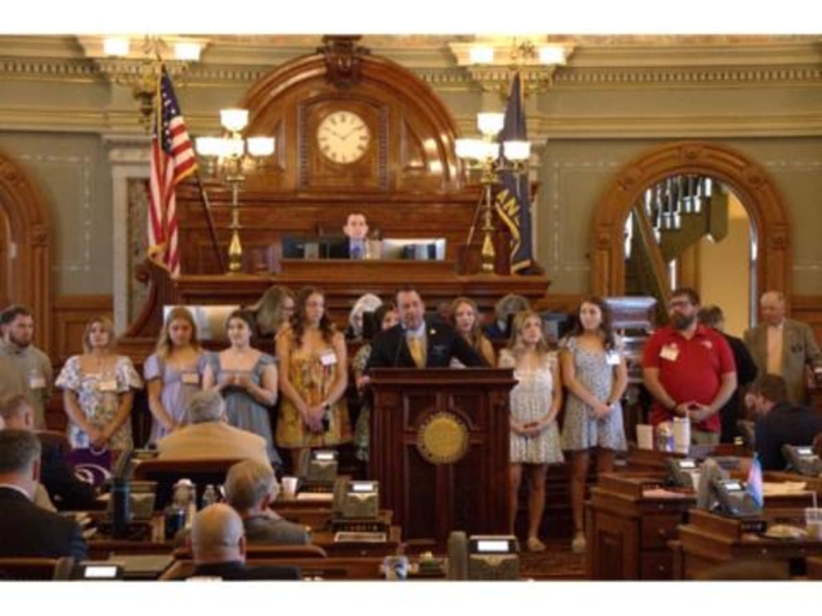 Russell High School Lady Broncos wrestling team with Kansas officials celebrating championship win