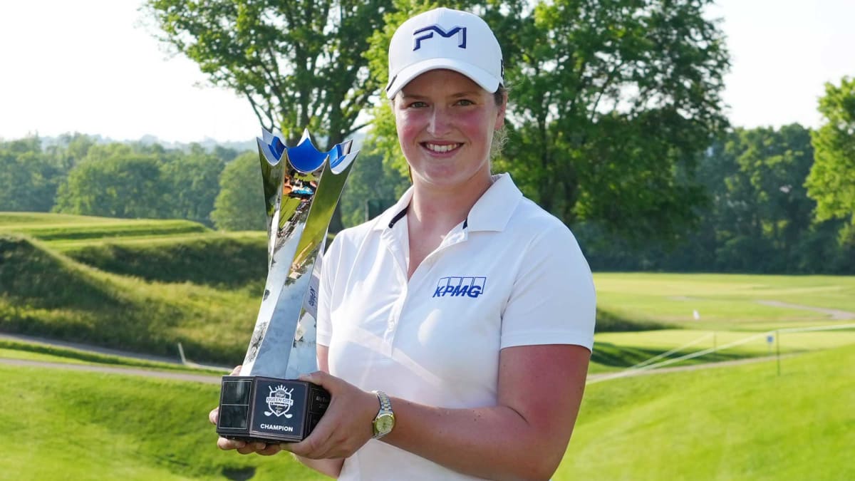 Lottie Woad holding championship trophy on 18th green at Maketewah Country Club