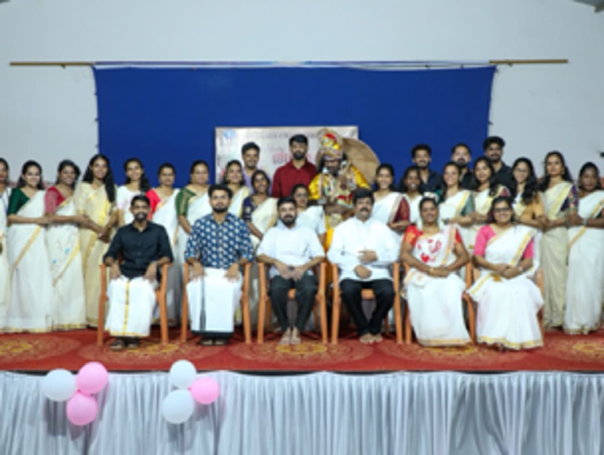 ** Residents and staff members sitting together sharing traditional Onam feast on banana leaves