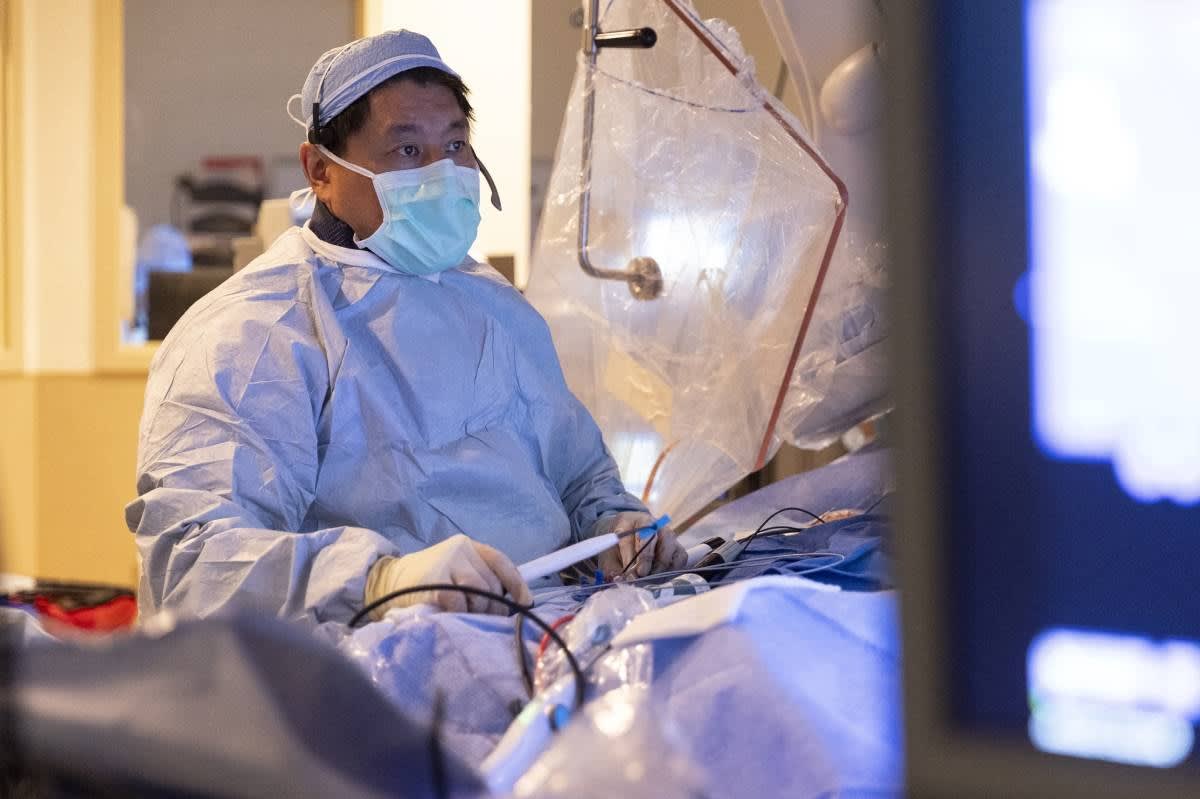 Medical researcher in white coat examining data in modern Arizona research laboratory facility