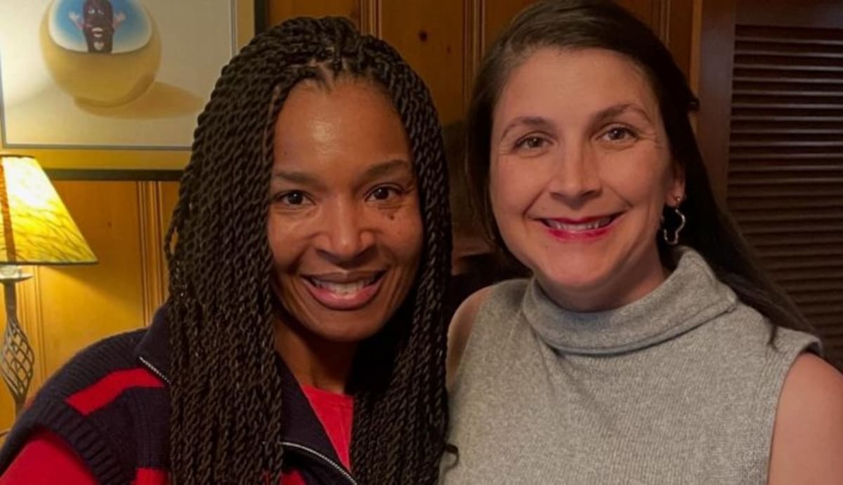 Young woman Elle Crofton smiling while holding her newborn son Harry in hospital
