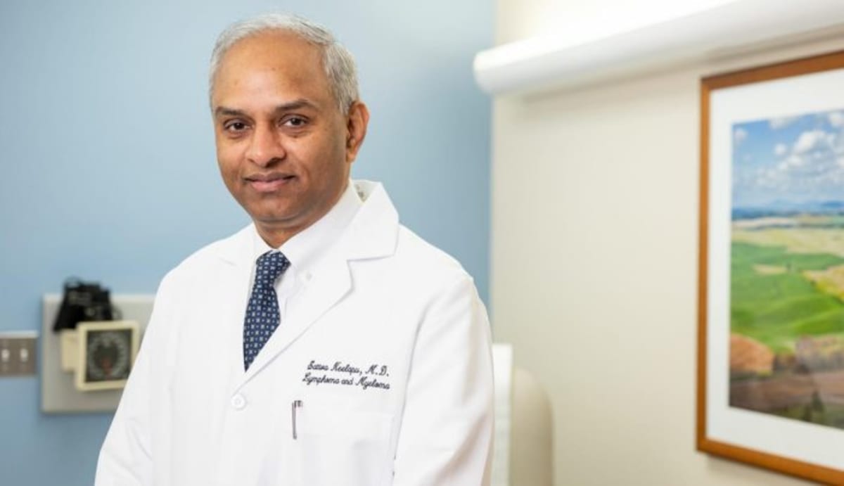 Medical researcher examining cell samples in laboratory conducting cancer immunotherapy research