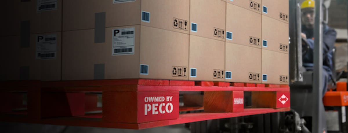 Stacked reusable wooden block pallets in warehouse showing sustainable shipping solution