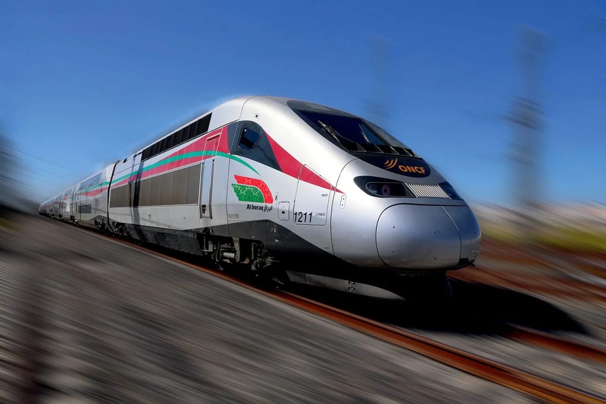 Modern high-speed train traveling through mountainous Moroccan landscape with Atlas Mountains backdrop