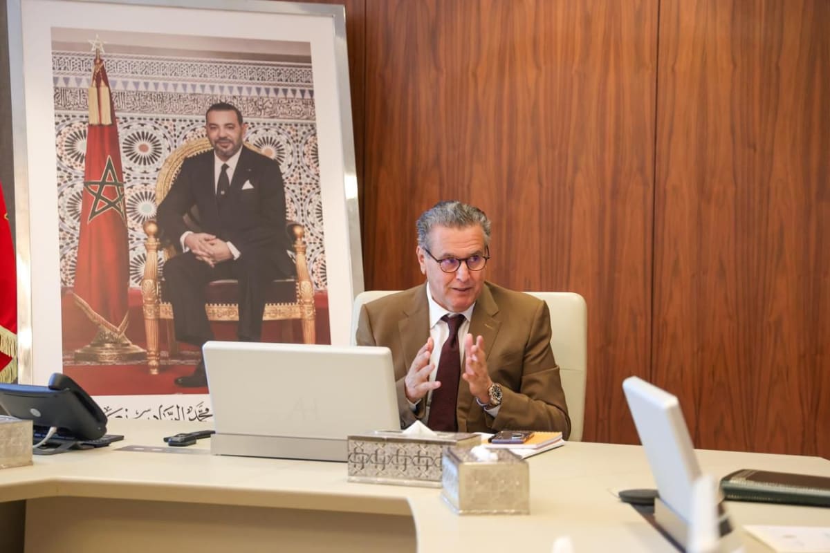 Moroccan university students walking on modern campus with new buildings and green spaces