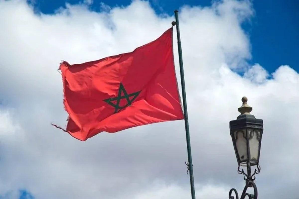 Moroccan flag waving against blue sky symbolizing nation's rise in global peace rankings