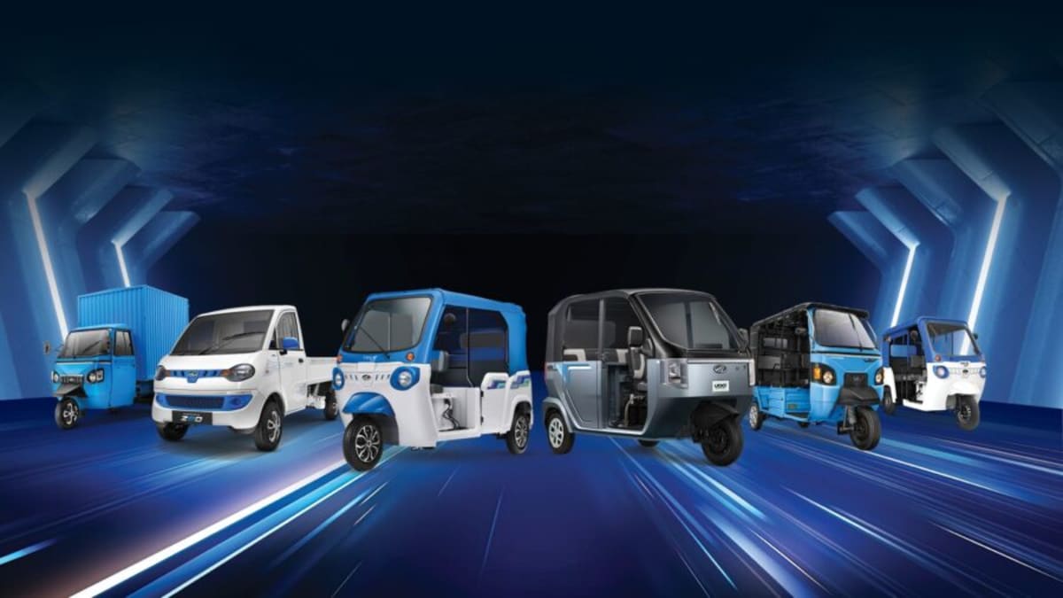 Green Mahindra electric three-wheeler vehicle used for deliveries on Indian city street