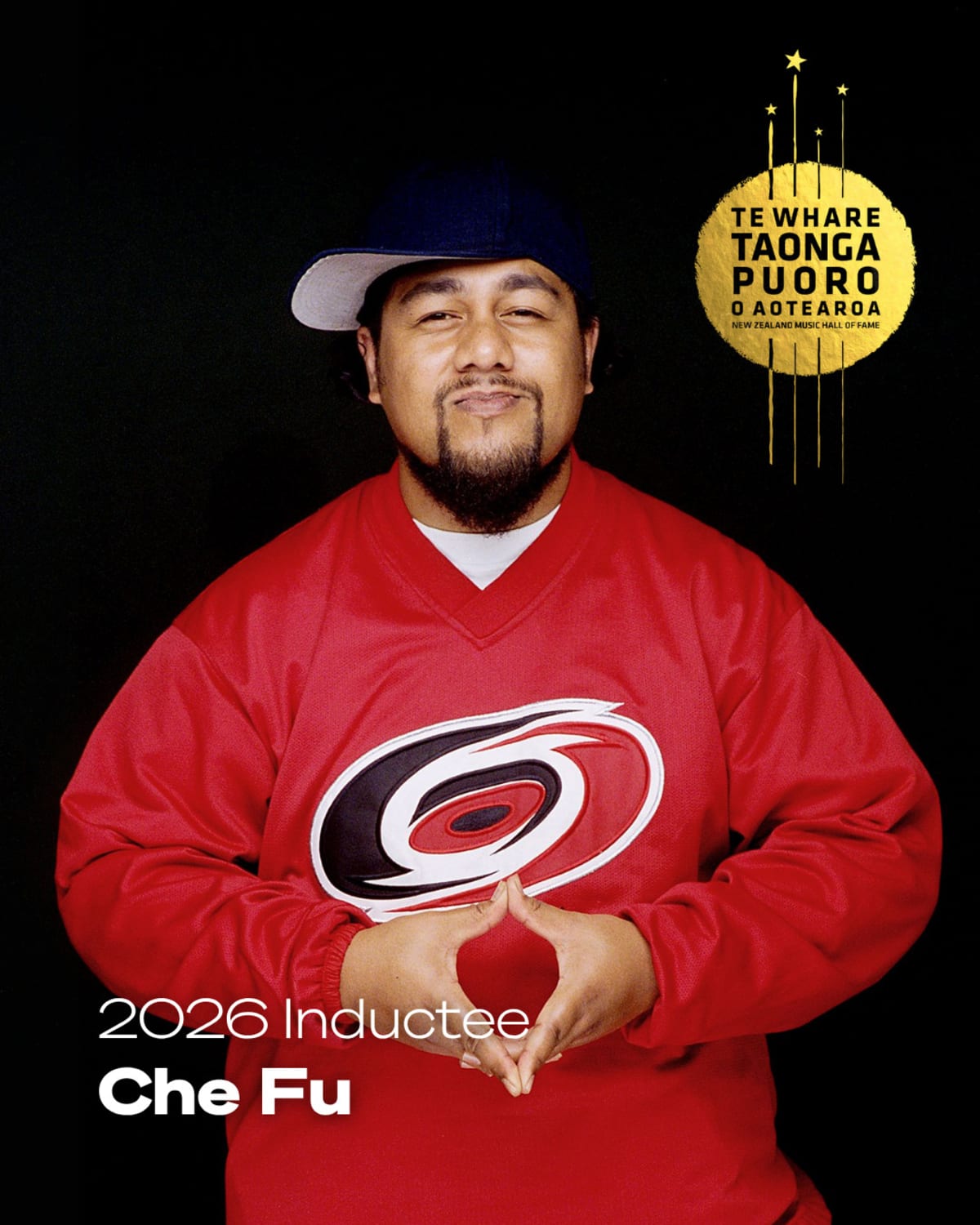 ** Che Fu performing on stage with band, celebrating decades of pioneering Aotearoa hip hop