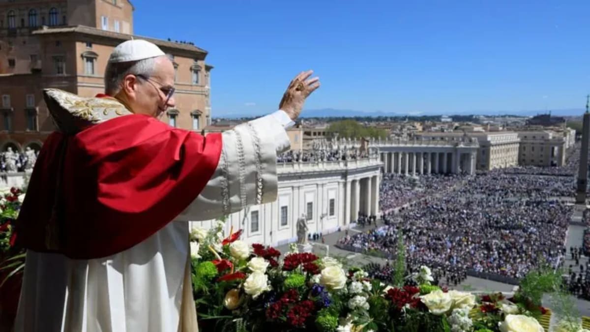 Pope Leo XIV on Vatican balcony surrounded by white roses addressing Easter crowd below