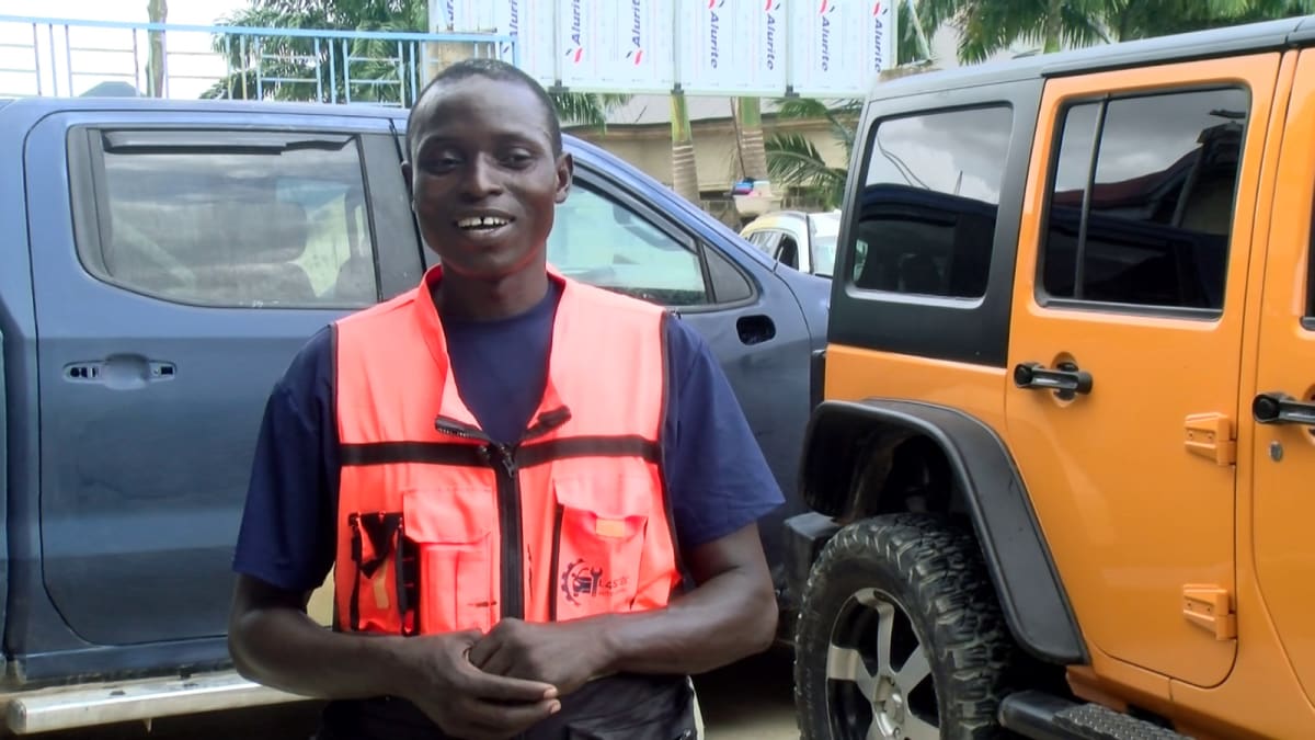 Busy automotive repair workshop in Accra with mechanics working on multiple vehicles