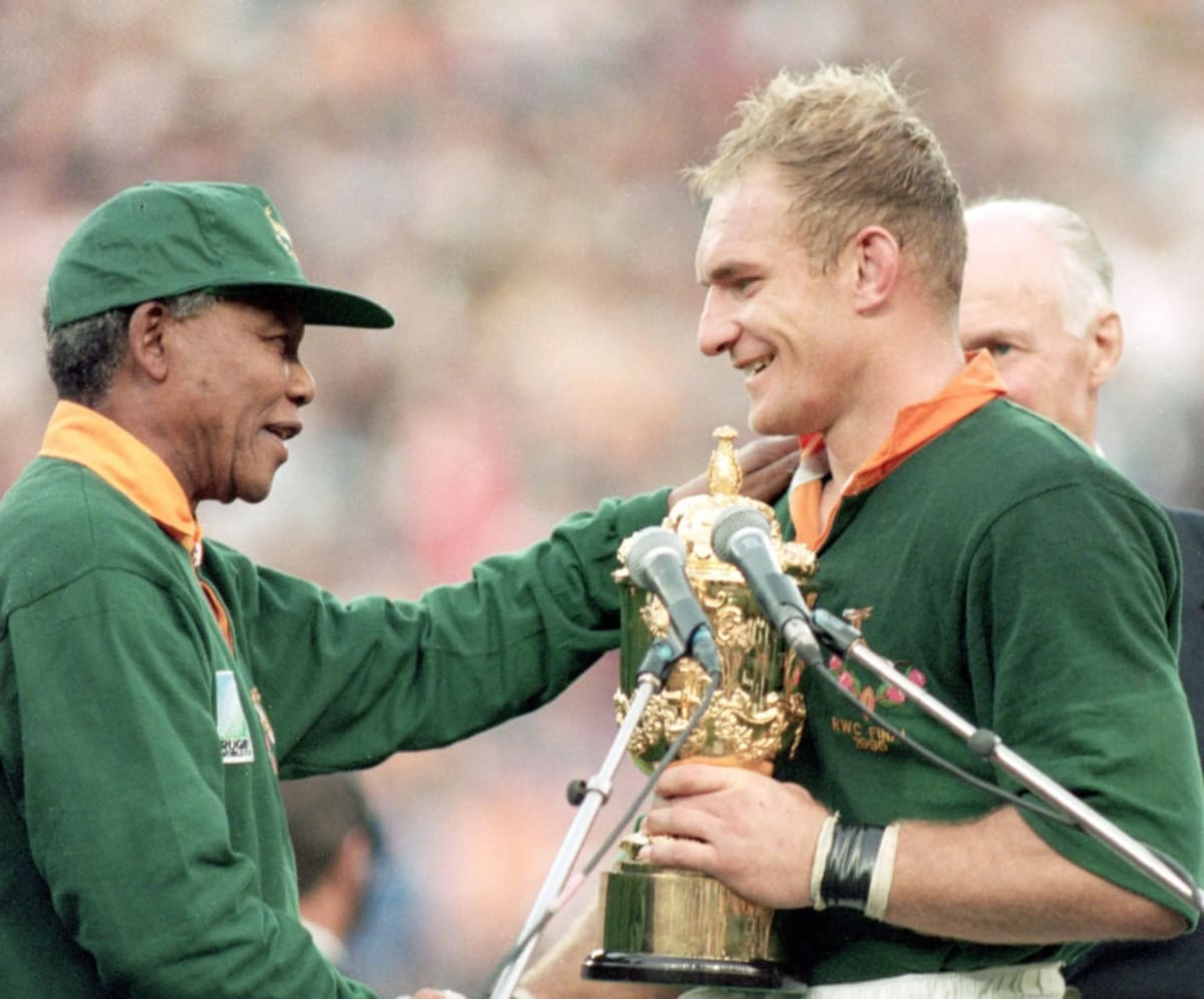 Nelson Mandela smiling at rugby event celebrating African youth sports development and equality