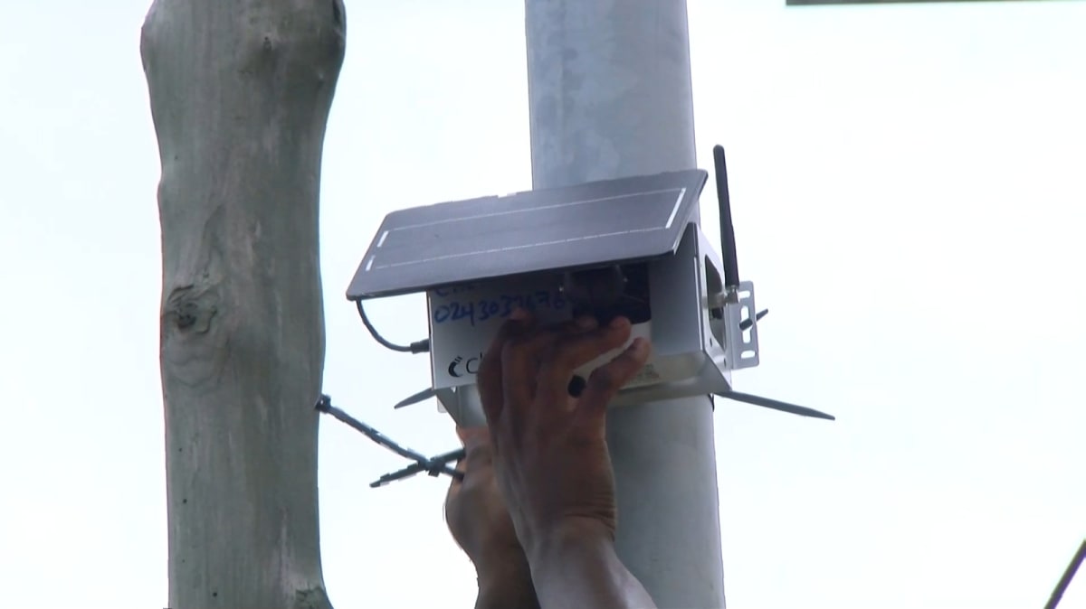 Air quality monitoring sensor mounted on pole in urban Accra neighborhood tracking pollution levels