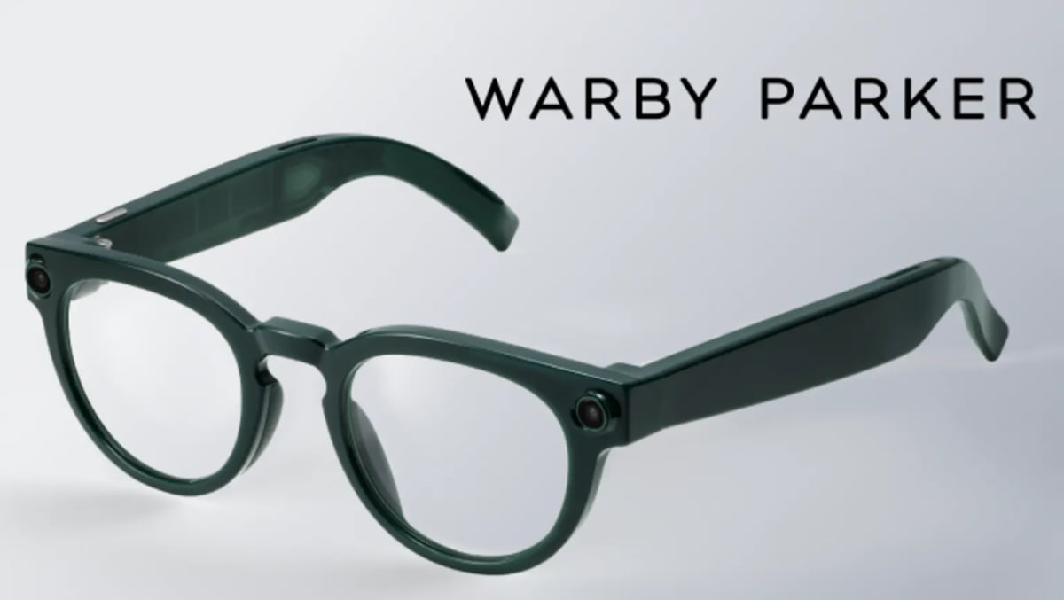 Person wearing modern smart glasses with subtle camera and speakers integrated into frames