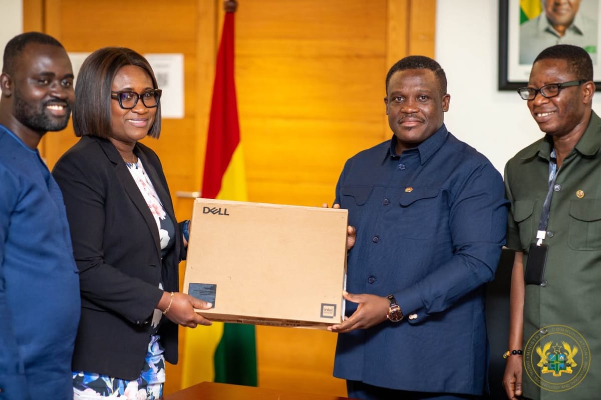 Ghana Communication Minister presenting laptop computers to parliamentary officials in Accra conference room
