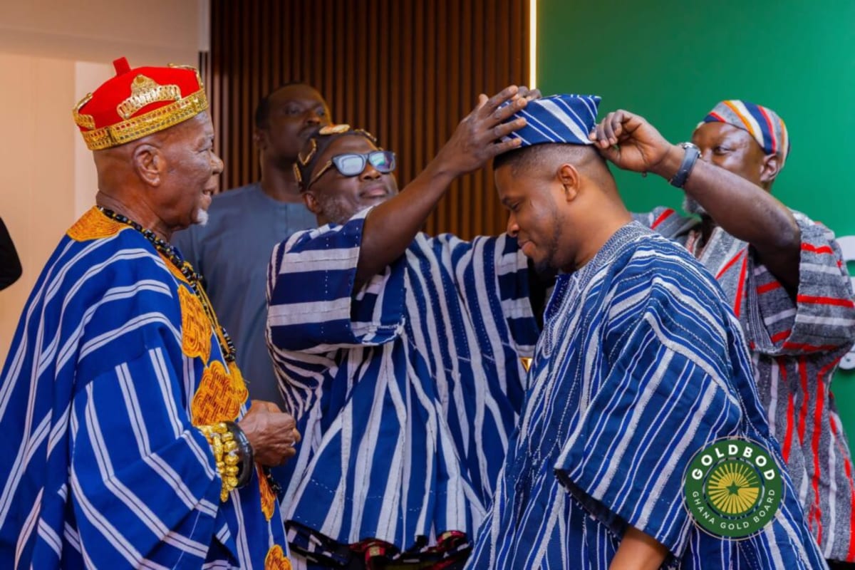Traditional leader presenting ceremonial spear medal to business executive in formal ceremony