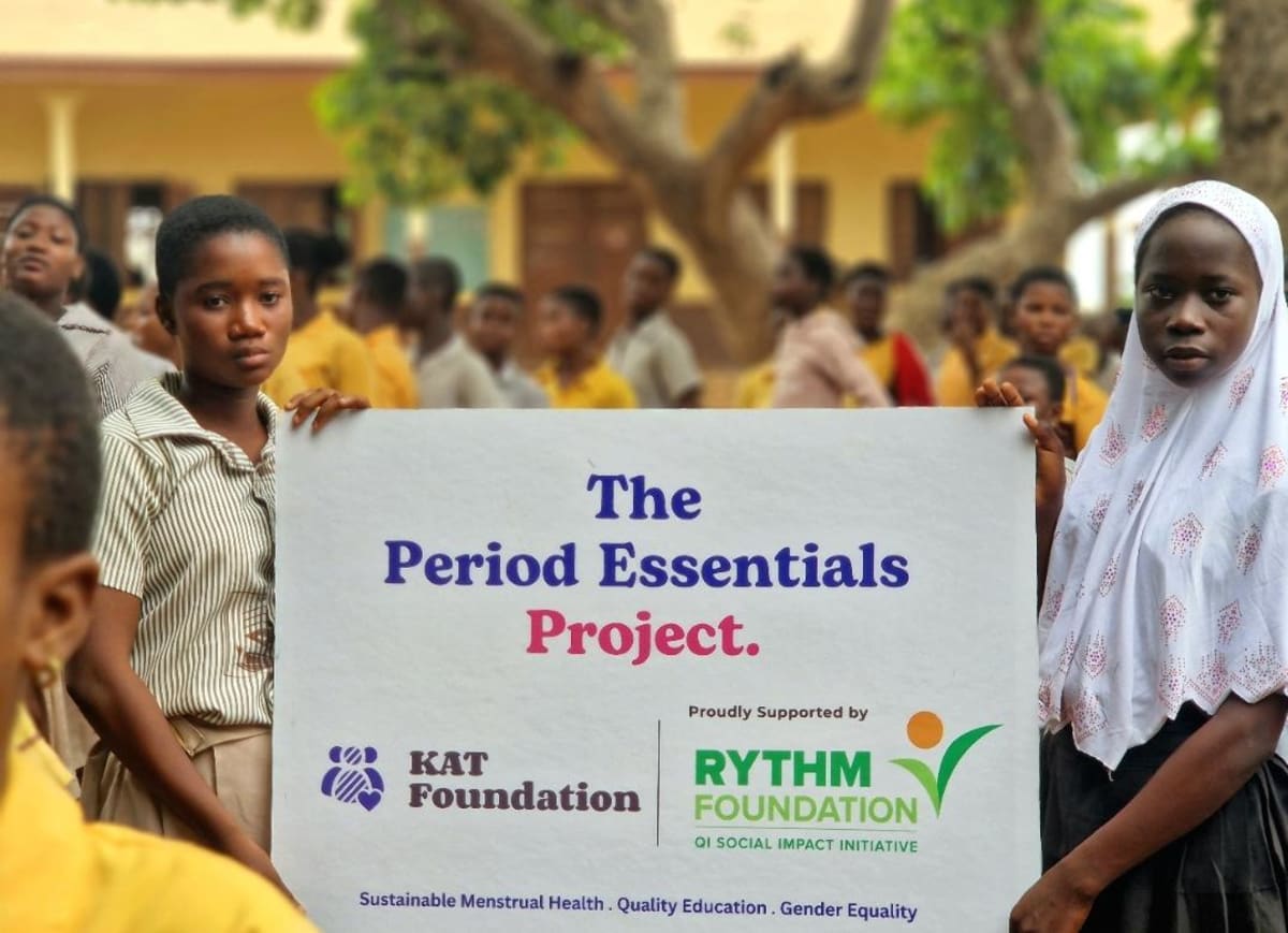 Ghanaian schoolgirls in uniforms smiling with reusable menstrual health products in classroom