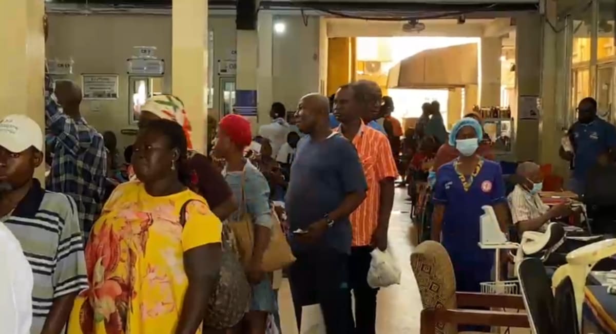 Busy hospital waiting room with patients and medical staff at Komfo Anokye Teaching Hospital in Ghana