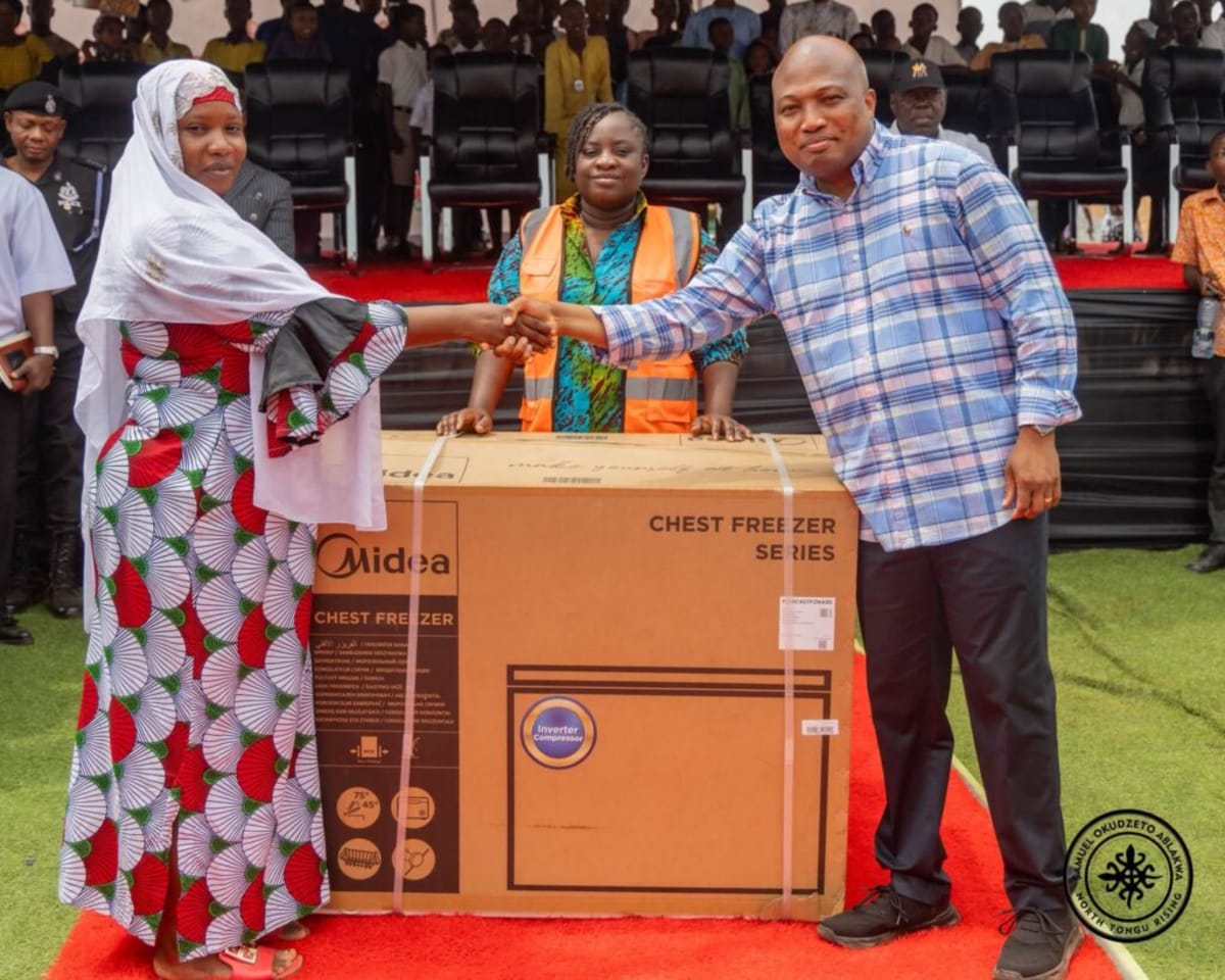 Market women in Ghana receiving chest freezers to support their businesses during relocation