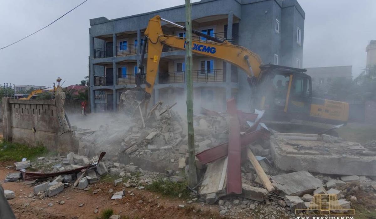 Construction equipment clearing drainage channels and removing structures along Accra waterways for flood prevention