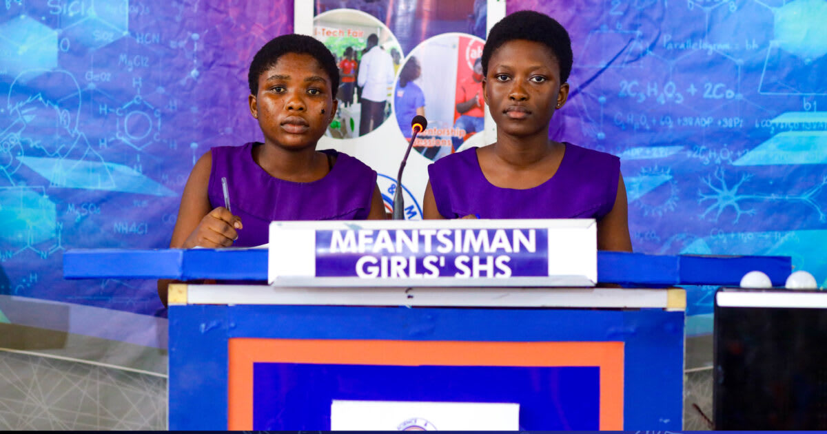 Ghanaian female students in uniform celebrating their science quiz qualification victory with raised arms
