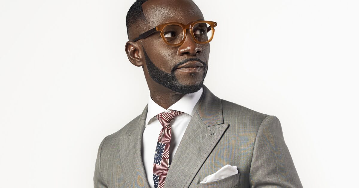 Ghanaian rapper Okyeame Kwame speaking at public health event in traditional clothing