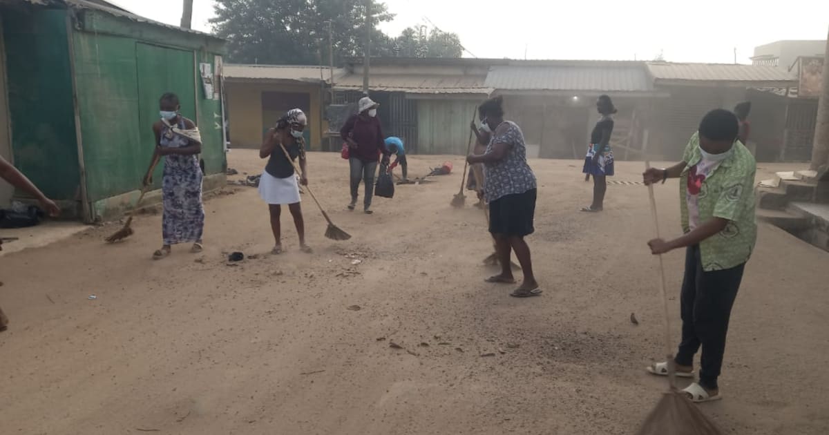 Ghanaian community members cleaning streets and clearing gutters together in Awutu Bereku township