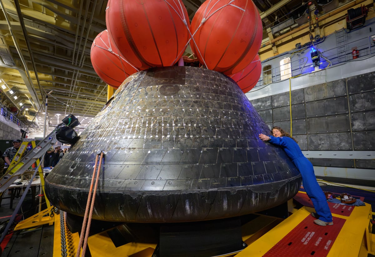 NASA astronaut Christina Koch embraces Orion spacecraft in ship's well deck after Moon mission