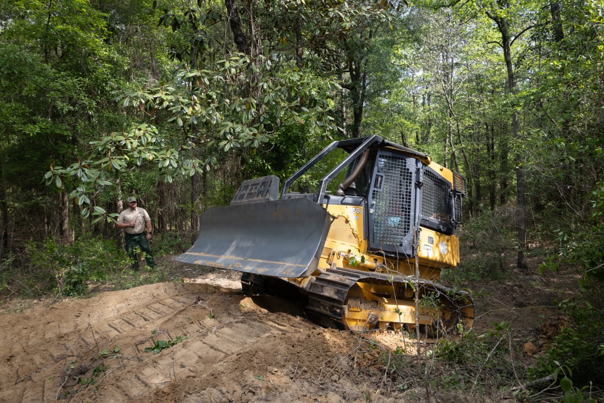 NASA scientist learning to operate Alabama forestry bulldozer equipped with new thermal safety sensor